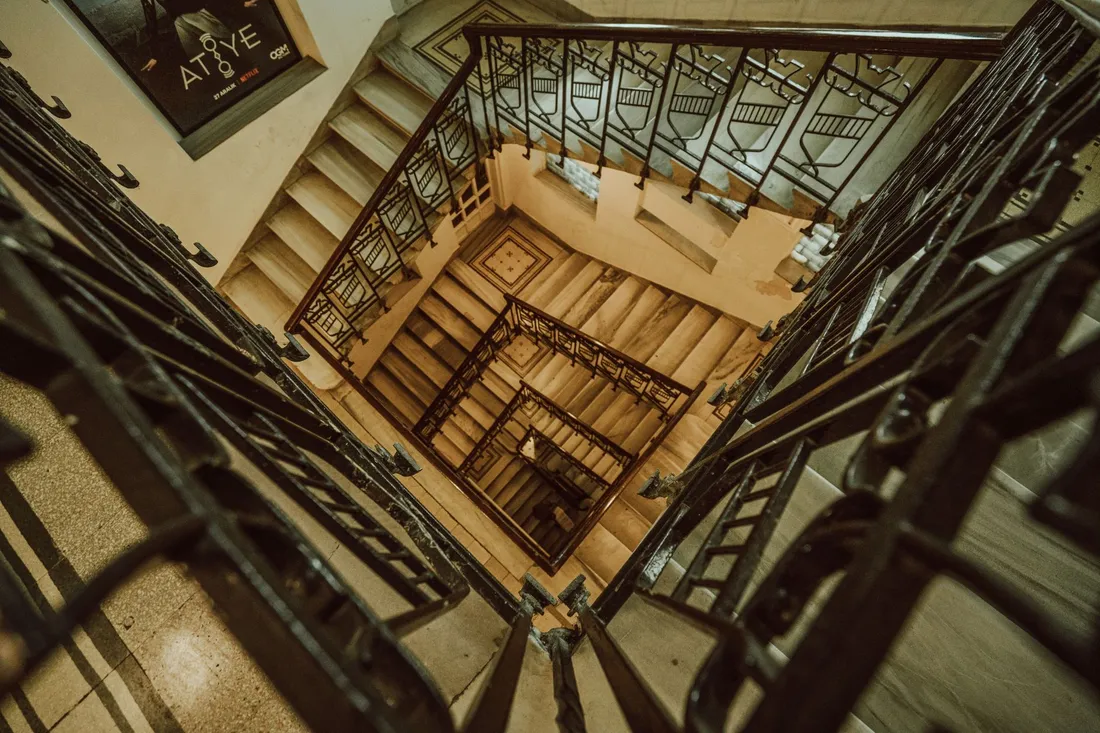 Treppenhaus in einem Altbau mit Holzgeländer und hohen Decken
